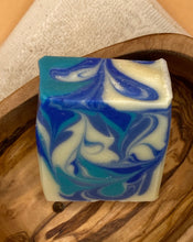 Afbeelding in gallerijweergave laden, Gone to the beach soap in a soap bowl made out of olive wood.  Its good for hand and body soap  and it contains  all natural plant oils. It is very good for your skin. It has 3 different blue and a white color in a nice design. It has a nice fresh fragrance reminding one of a scent from the sea. 
