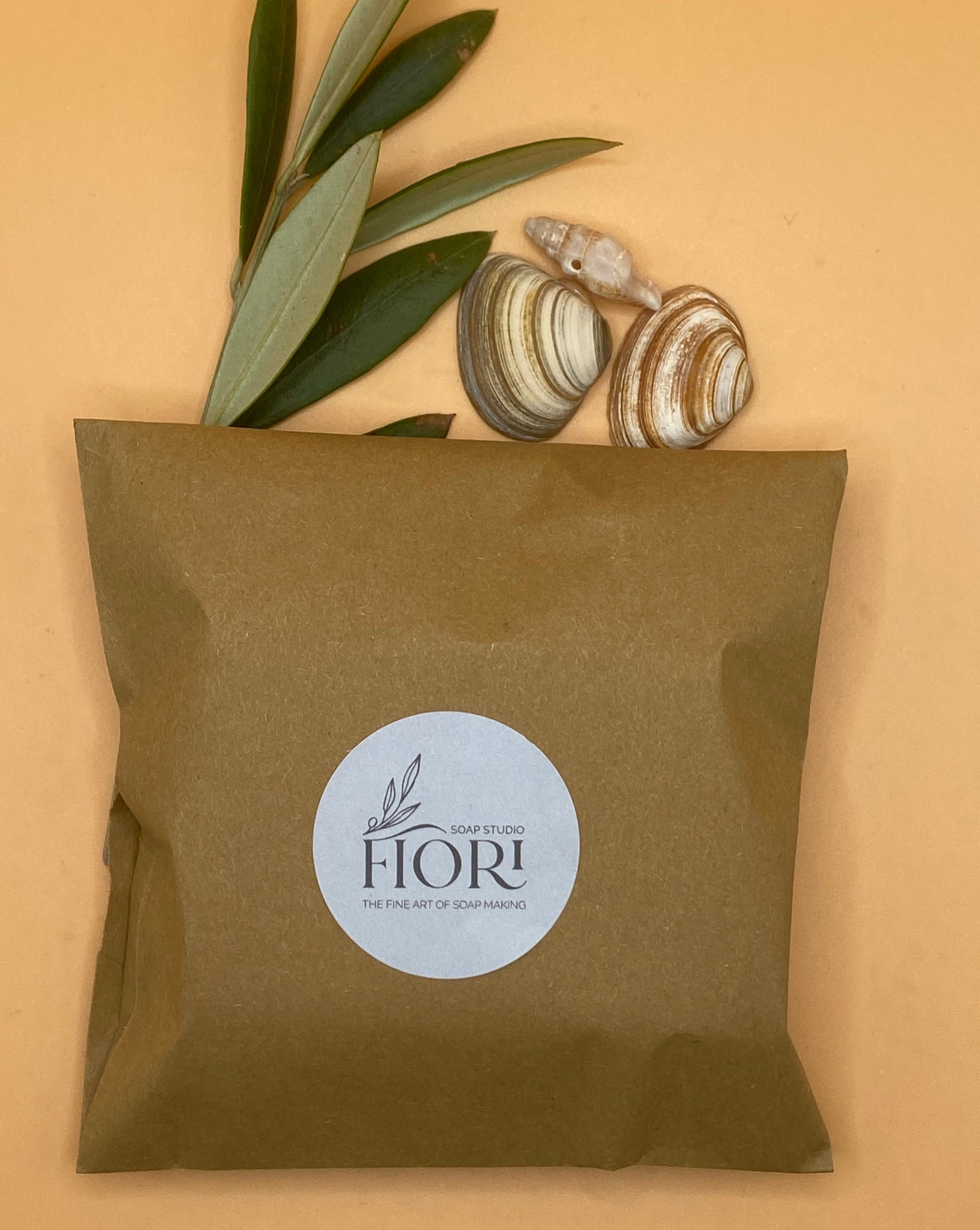 Gone to the beach soap handmade in the Netherlands by Soap Studio Fiori is shown wrapped in a brown paper bag as one of the packaging options. This soap has a rich lather and  is mild to your skin. It has a fresh scent reminding of the sea. A beautiful blue and white pattern makes this handmade soap uniquely beautiful.